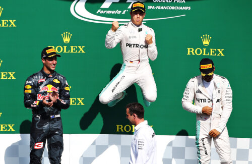 Rosberg sare de bucurie pe podium în aplauzele lui Ricciardo, într-un moment în care Hamilton (dreapta) tocmai îşi încheia fermoarul jachetei // FOTO Guliver/GettyImages