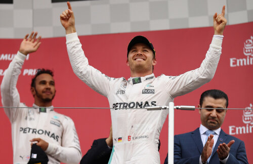 Nico Rosberg sărbătoreşte în prim-plan, Lewis Hamilton îşi salută fanii de pe treapta a treia a podiumului // FOTO Guliver/GettyImages