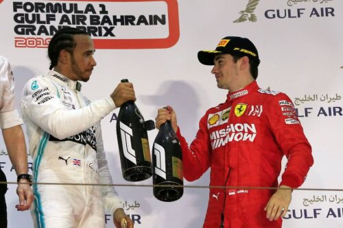 Lewis Hamilton, învingătorul nesperat, și Charles Leclerc, învinsul ghinionist, ciocnindu-și sticlele de șampanie (foto: Reuters)