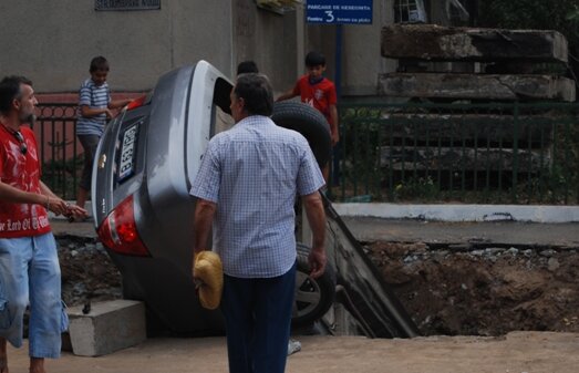 Accident uluitor în Capitală: Maşină înghiţită de o gaură în asfalt