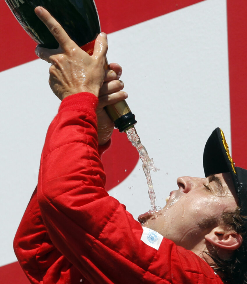 Fernando Alonso îşi toarnă cu dexteritate şampanie direct în gură // Foto: Reuters