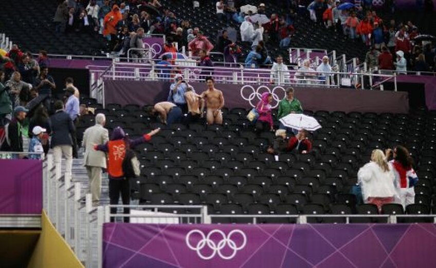 Hei, voi ce faceţi aici?
Toată lumea rîde de striperii de ocazie, mai puţin un steward (stînga, cu vesta Jocurilor Olimpice), care gesticulează nervos spre cei trei curajoşi
Foto: Reuters