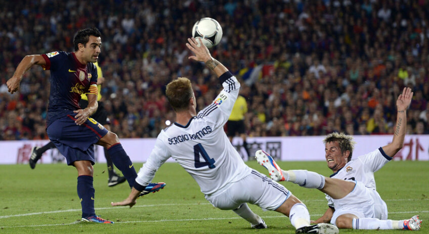 Doi jucători blanco, Sergio Ramos (nr. 4) şi Coentrao, plonjează ca nişte kamikaze în faţa mingii lui Xavi // Foto: AP/Rompres