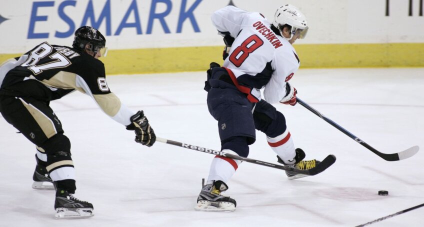 Alex Ovechkin (la puc), urmărit pe gheaţă de rivalul său, canadianul Sidney Crosby