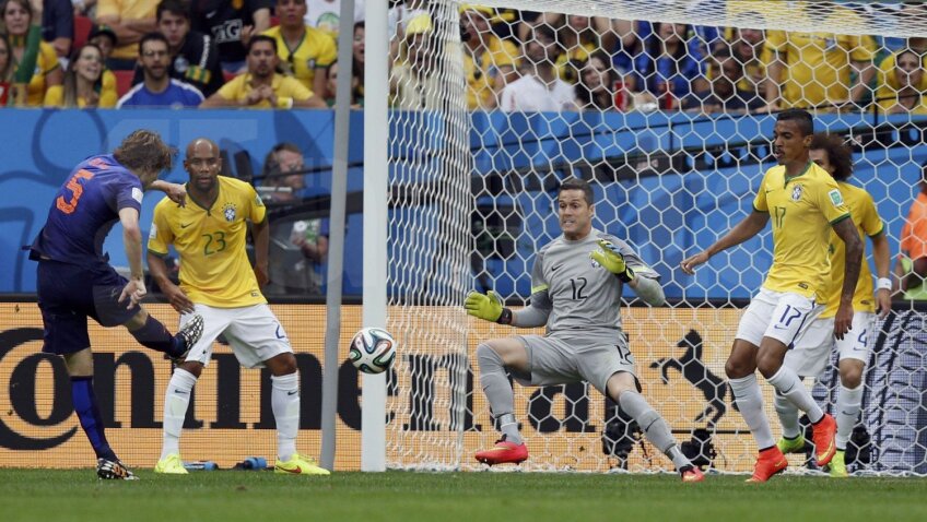 Stîngaciul Blind (în albastru) şutează perfect cu dreptul pe deasupra lui Julio Cesar. Brazilia - Olanda 0-2 // Foto: Reuters