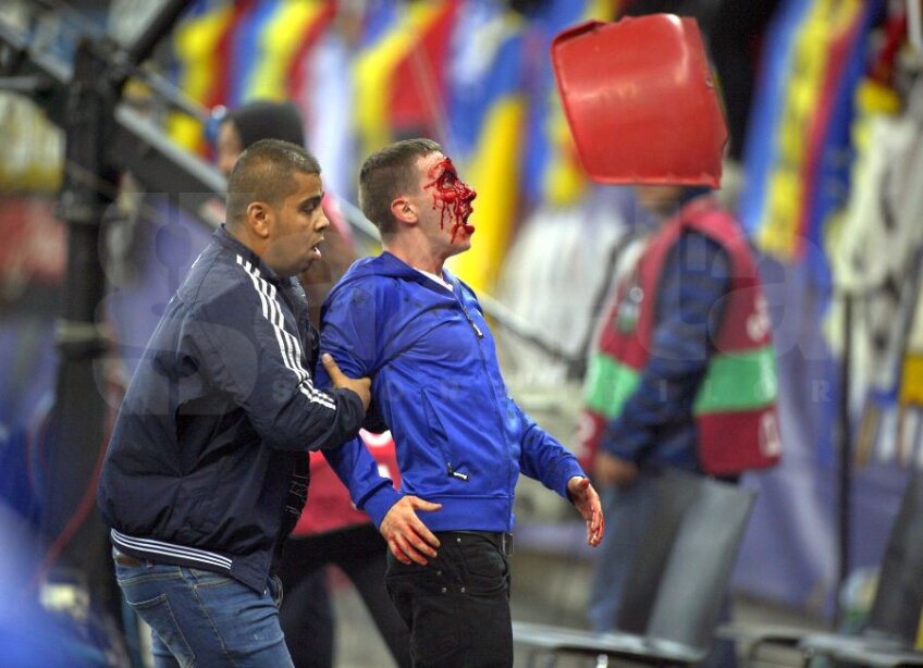 Un suporter român plin de sînge privește șocat către un scaun care
zboară din tribune spre teren
Foto: Ștefan Constantin