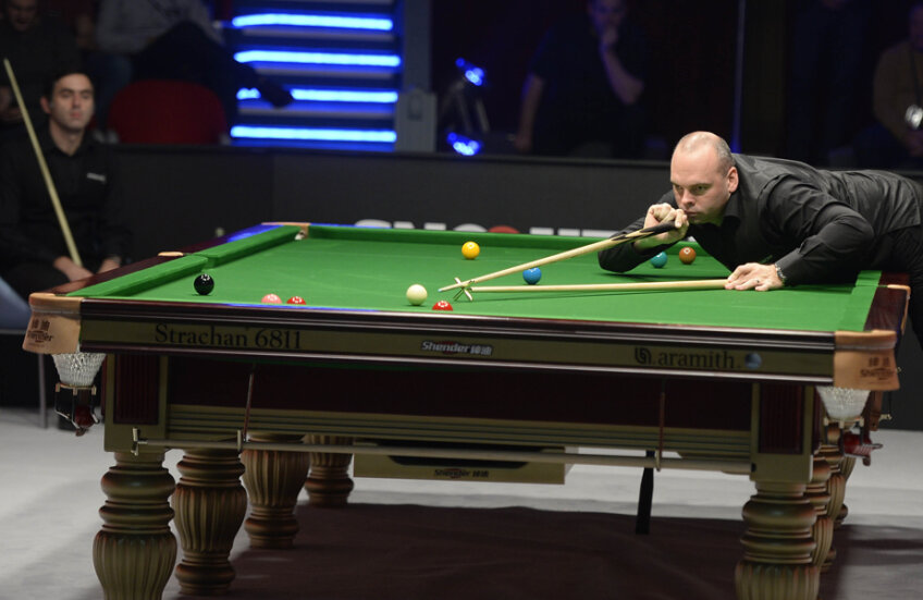 Stuart Bingham, campionul mondial en titre, execută o lovitură sub privirile lui Ronnie O'Sullivan // Foto: Alex Nicodim