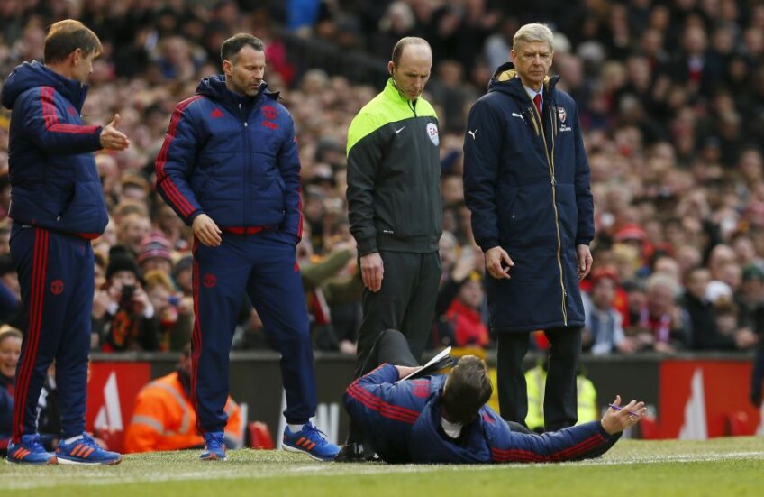 MAN DOWN. Van Gaal a oferit ieri imagini amuzante în repriza a doua a meciului Manchester United - Arsenal 3-2. A vrut să-i demonstreze arbitrului de rezervă că Alexis, atacantul adversarilor, a simulat și s-a aruncat pe  spate (foto: Reuters)