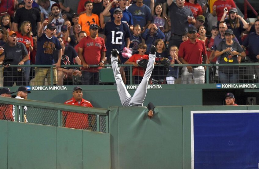 NOW YOU SEE ME... Austin Jackson (Cleveland Indians) cade peste zid în încercarea de a prinde mingea lovită de Hanley Ramirez (Boston Red Sox). Priviți expresiile de pe fețele celor din tribună. :) foto: Reuters