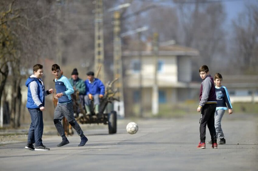Copiii se joacă fotbal pe ulițele satului Traian