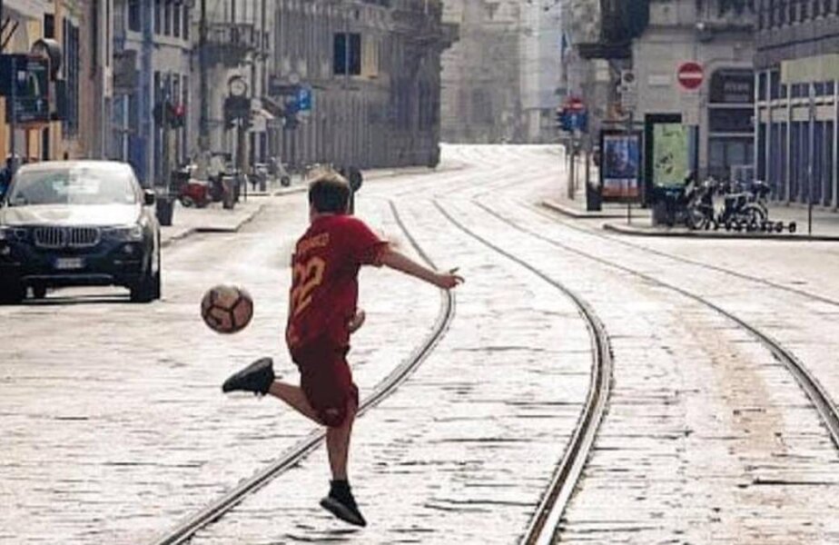 Simbolul speranței la Milano. Evadarea din carantină pentru fotbal. Un copil în tricoul giallorosso al lui Nicolò Zaniolo bate mingea pe o stradă pustie în capitala Lombardiei, cel mai mare focar de coronavirus din Italia. Poza a fost publicată ieri de Corriere della Sera și a devenit imediat virală. „O imagine superbă!